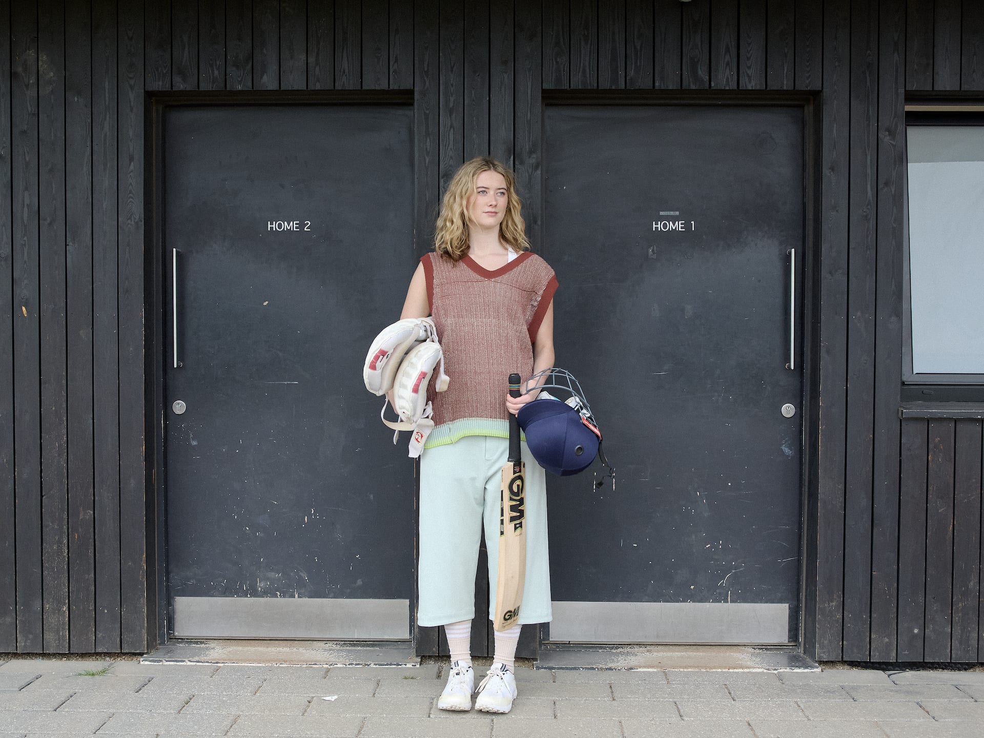 Mollie Bicknell holding cricket equipment